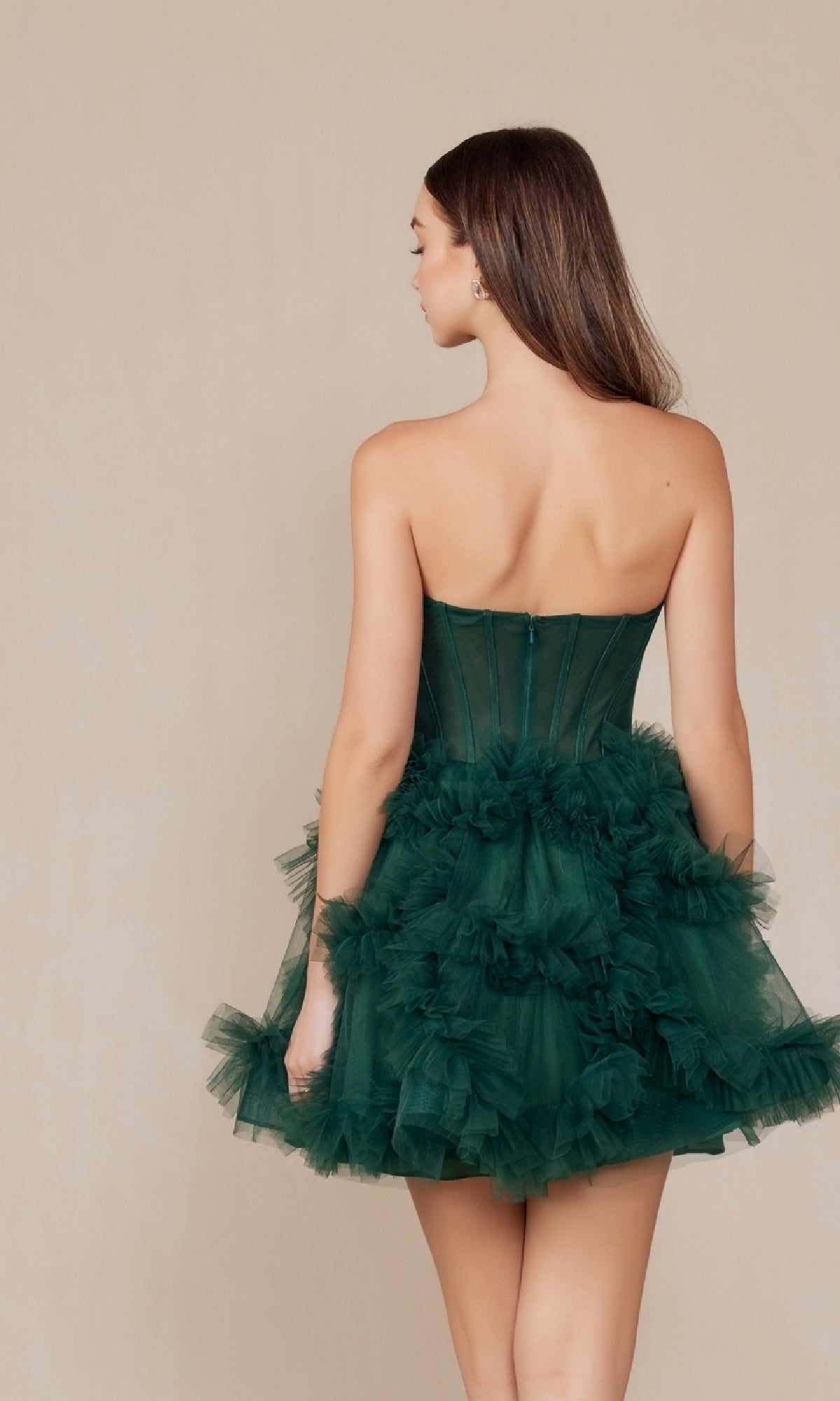 A woman faces away, wearing the Short Strapless Ruffled Homecoming Dress Y859—a dark green tulle A-line dress with a fitted bodice and layered ruffled skirt, perfect for any party.